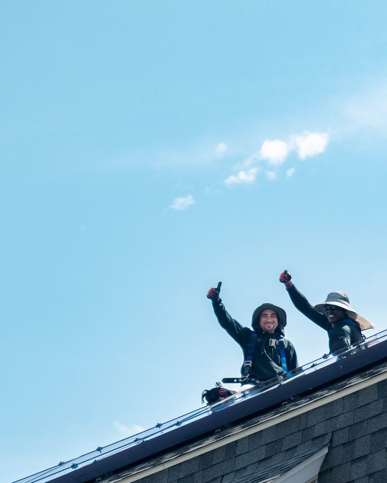 BHS crew celebrating a finished solar installation on a roof
